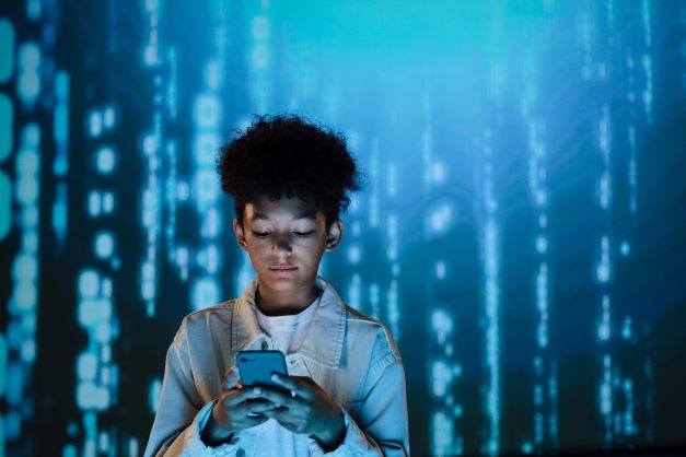 Deal with cyberbullying; a young teen looks at his phone