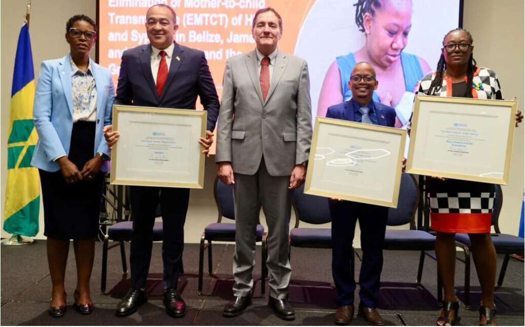 Mother-to-child transmission; The Jamaican Minister of Health is standing with four other people,including the Director of PAHO, Dr. Jarbas Barbosa, to celebrate the country's achievement of the elimination of mother-to-child transmission of HIV and syphilis.