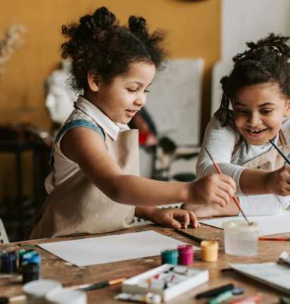 Girls in Brown Apron Holding Paint Brushes