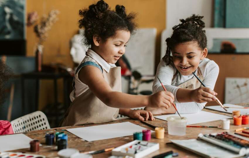 Girls in Brown Apron Holding Paint Brushes