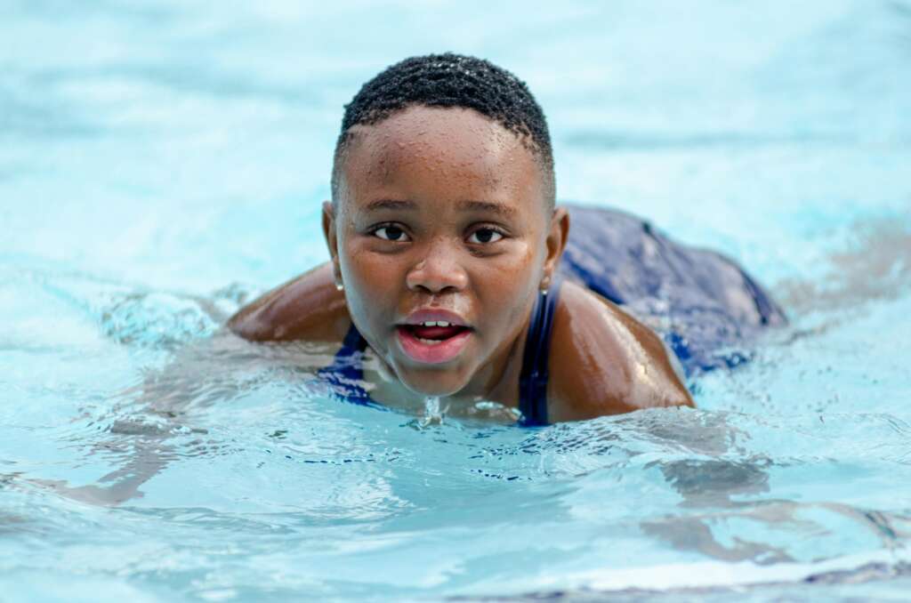 Kid Swimming in Pool; Summer Water Safety Tips