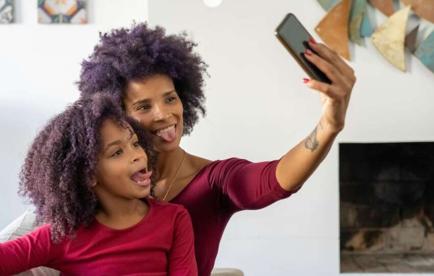Mother and Daughter Taking a Selfie and Sticking Their Tongues Out