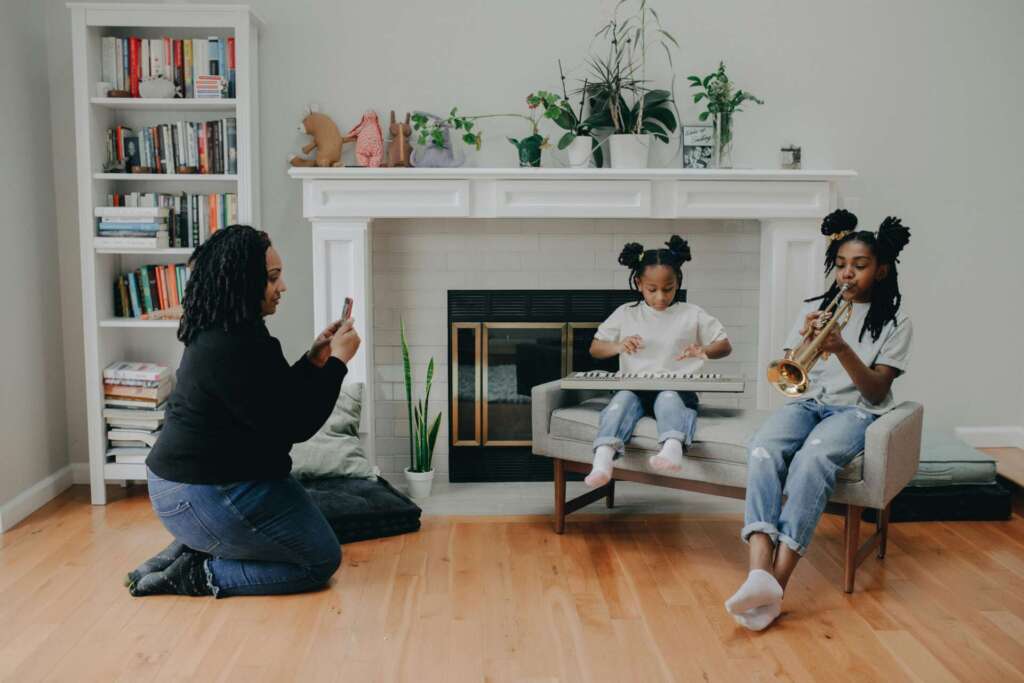 Mother taking a photo of her children playing musical instrument; Mindful Sharenting
